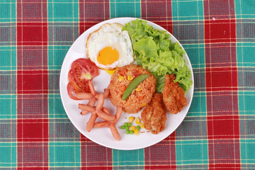 American fried rice topped sunny up,sausage.chicken and herbs