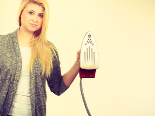 Woman holding iron about to do ironing