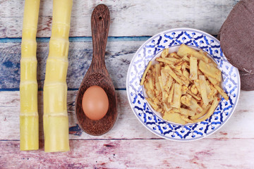Fried soft bamboo pole shoots with egg and kitchen equipment cooking.