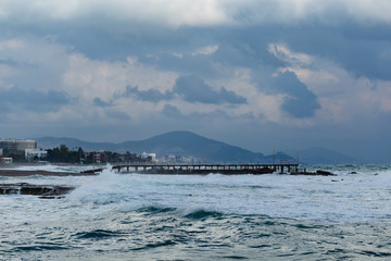 Seascape with mediterranean town during storm