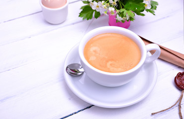 Cup with coffee on a white wooden surface