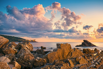Rocks and buildings on the sea at sunset. Livorno, Tuscany riviera, Italy