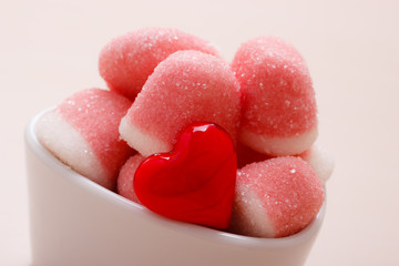 Fototapeta na wymiar Pink jellies or marshmallows with sugar in bowl