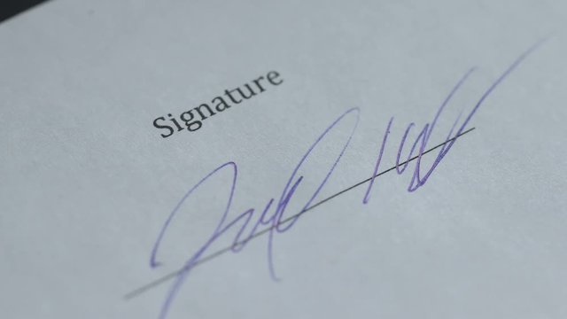 Closeup of person signing document