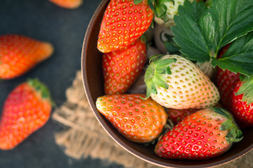 Close up Top view of Red Strawberries and leaf with black stone background