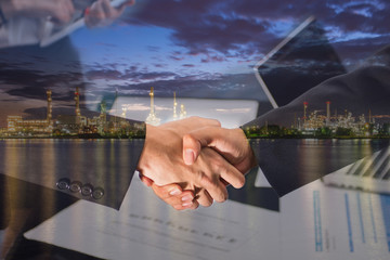 Double Exposure of a businessman handshake on Oil refinery factory in the morning.