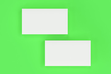 White blank business cards mock-up on green background