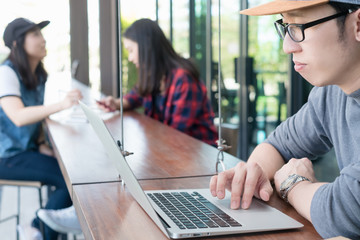 Smart asian man in casual style using laptop for work in coffee shop cafe.