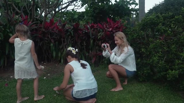 Mom takes pictures of her daughter's hair decorated with flowers of Plumeria stock footage video