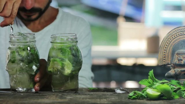Bartender stirs mojito cocktail