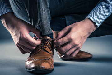 革靴の紐を結ぶ男性