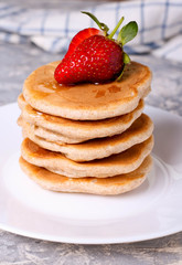 Homemade pancakes with strawberries on white plate