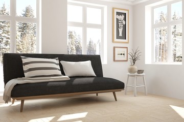 Fototapeta premium White room with sofa and winter landscape in window. Scandinavian interior design. 3D illustration