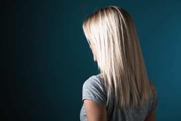 Woman with beautiful straight blonde hair on a blue background