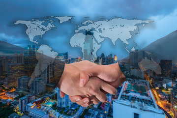 Double Exposure of a businessman handshake on World Global Cartography Globalization with Aerial view of Bangkok modern office buildings, condominium in Bangkok city downtown with twilight sky.