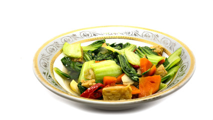 mustard fried vegetables on a plate, on a white background