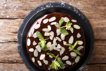 Delicious sweet chocolate cake with whipped cream and almond close-up on the table. horizontal top view