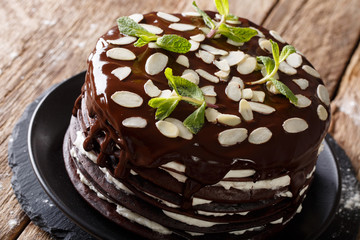 Chocolate crepes cake with whipped cream decorated with almonds and mint. horizontal