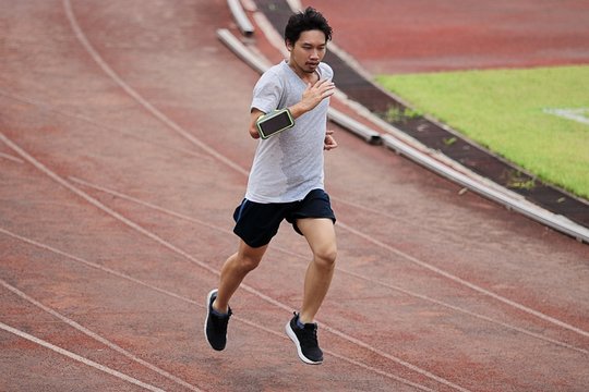 Lifestyle of young healthy Asian man runner running on racetrack