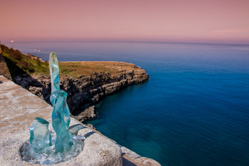 Kunst aus Glas und Küste von Polignano a Mare in rosa Sonnenlicht