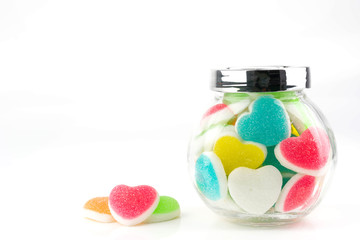 Heart candies coated with sugar, heart colorful sweet candies, sugar heart shaped candy in glass bottle
