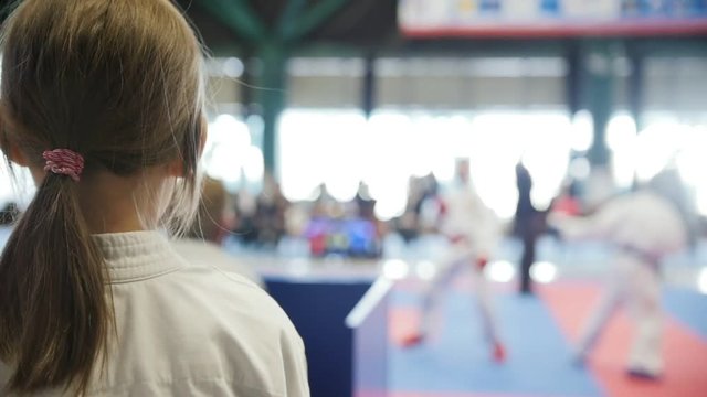 Teenager karate sports girl looking to fight on tatami - spectator - slow-motion