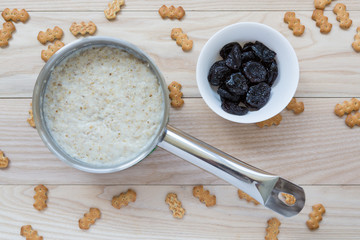 Oatmeal in stainless saucepan and dried fruits