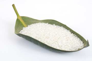 Rice grain in a green leaf on the white background