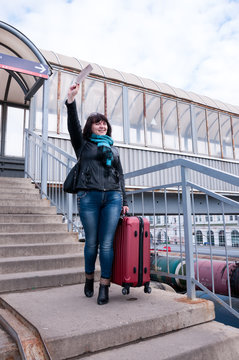 Woman is standing on a platform and waving her hand