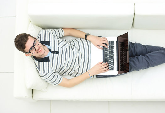 Man Relaxing on Sofa with Laptop Computer