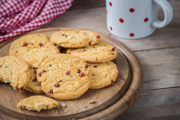Raspberry cookies on wooden plate and coffee cup