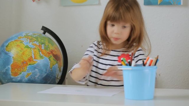 Small girl drawing with the colourful pencils