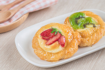 Danish pastry with fruit on plate.