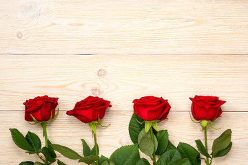 Fototapeta na wymiar 4 red roses in row over white rustic wood planks