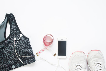 Flat lay of smartphone with measuring tape, sport bra and sport shoes on white background with copy space, Healthy lifestyle and diet concept