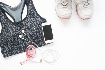 Flat lay of smartphone with measuring tape, sport bra and sport shoes on white background with copy space, Healthy lifestyle and diet concept