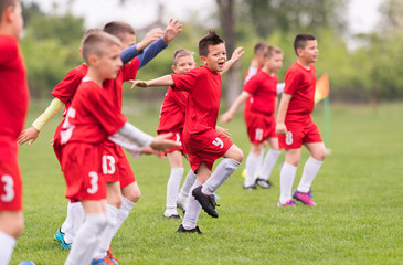 Kids soccer football - children players exercising before match on soccer field