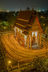 Thai buddhism culture in important date. long exposure of Thai buddhists carry the candle and walk around temple three rounds.