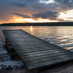 Fototapeta na wymiar Landscape with pier and sunset at summer evening in the lake in Finland