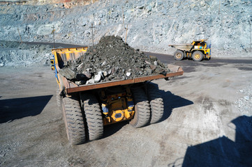 Heavy dump truck carrying the iron ore on the opencast mining