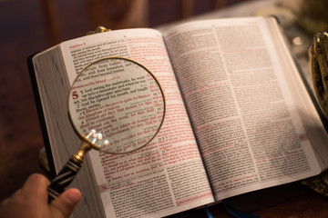 Reading with magnify glass the Bible Matthew 5  - 150891055
