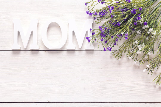 Mothers day background with bouquet of pretty flowers on a white wooden table. Space for text.