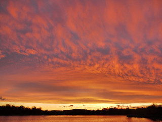 Sonnenuntergang am See, rote Wolken. 