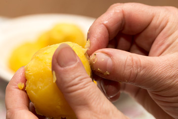 Woman cleaning potatoes with her hands