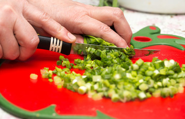 Cook cuts green onions with a knife