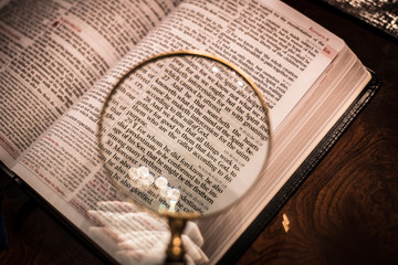 Reading with magnify glass the Bible Romans 8