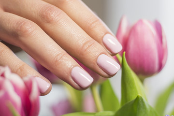 Obraz na płótnie Canvas Pink female nails and tulips