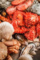 Fototapety  Talerz kuchni z owocami morza jako tło kolacji dla smakoszy oceanu. Kraby, muszle, ostrygi, krewetki i inne przysmaki z owoców morza.
