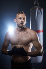 Fototapeta na wymiar Waist up of muscular male boxer .