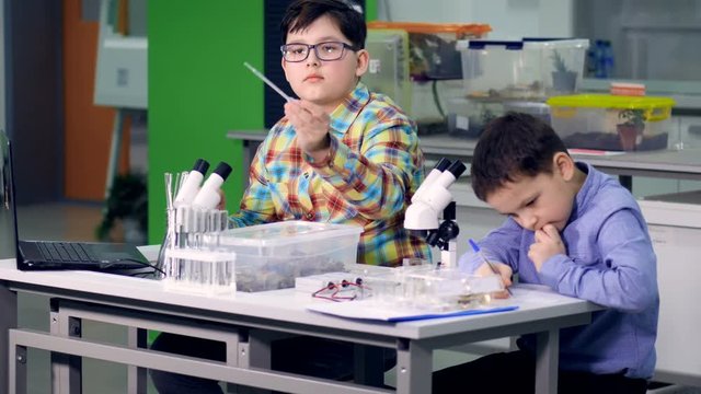 The boys in the laboratory performing the study, science experiment. 4K.